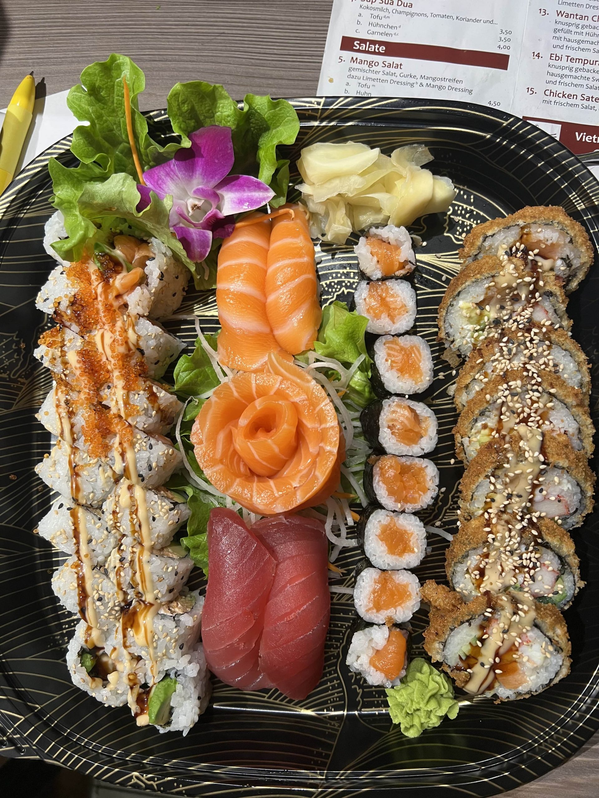 California Rolls, Sashimi und Maki auf schwarzem Teller